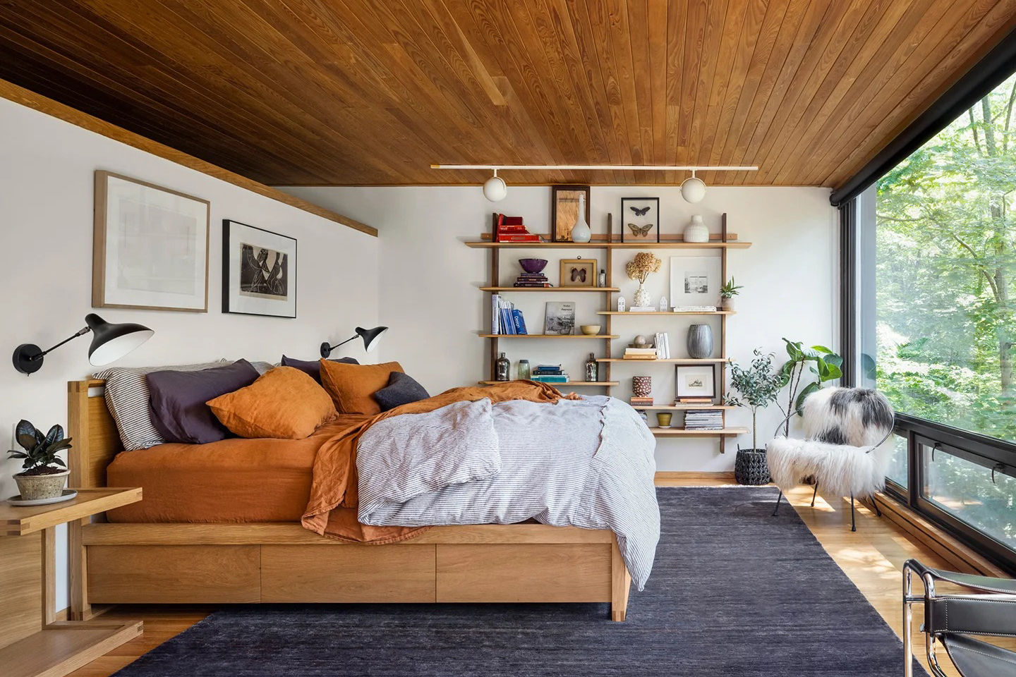 Bedroom with wood platform bed and book shelves.