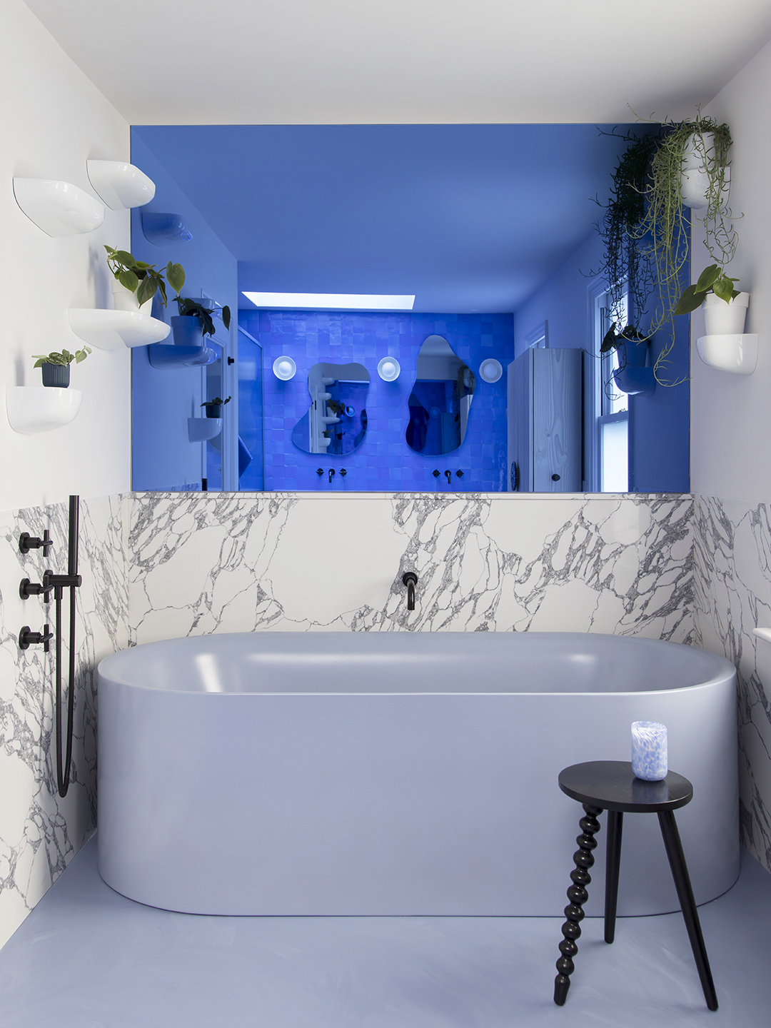 Blue tiled bathroom with blue freestanding tub.