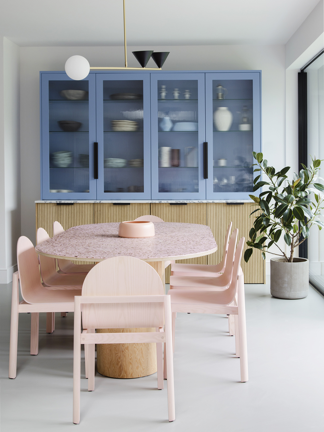 Dining room with pink dining set and blue cabinets.