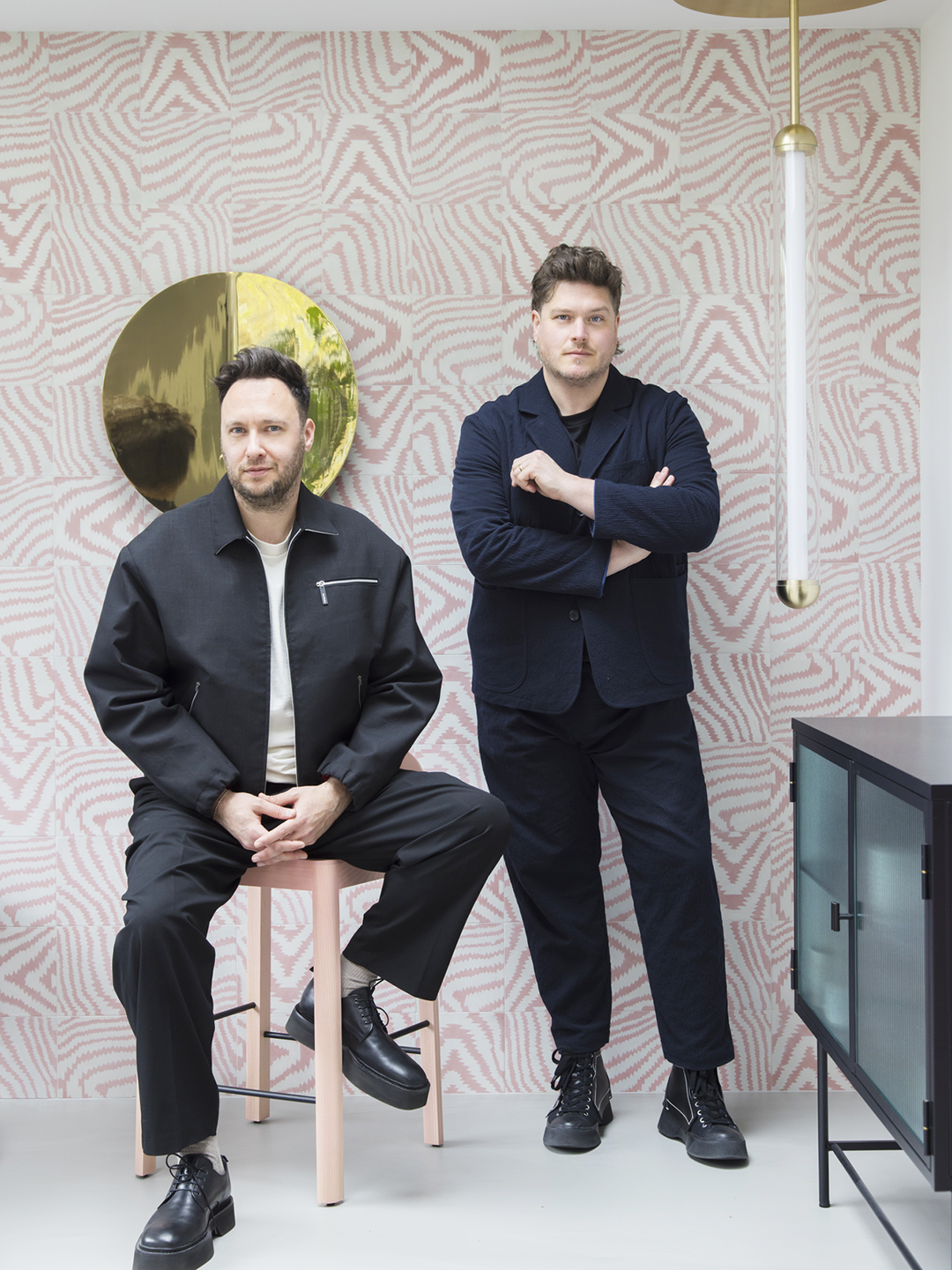 Portrait of 2LG founders Jordan Cluroe and Russel Whitehead behind pink tiled wall.