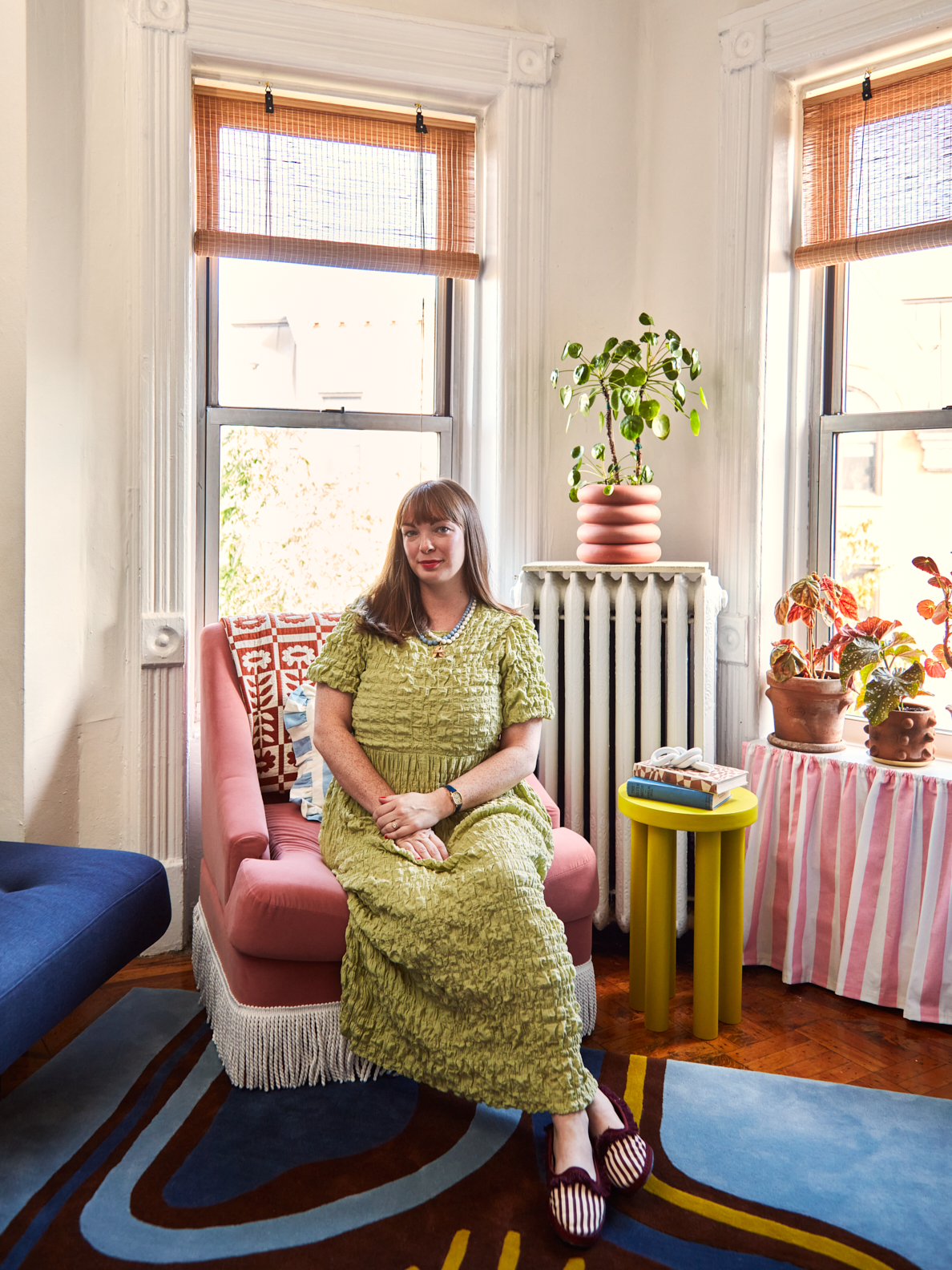 Woman on pink chair in living room