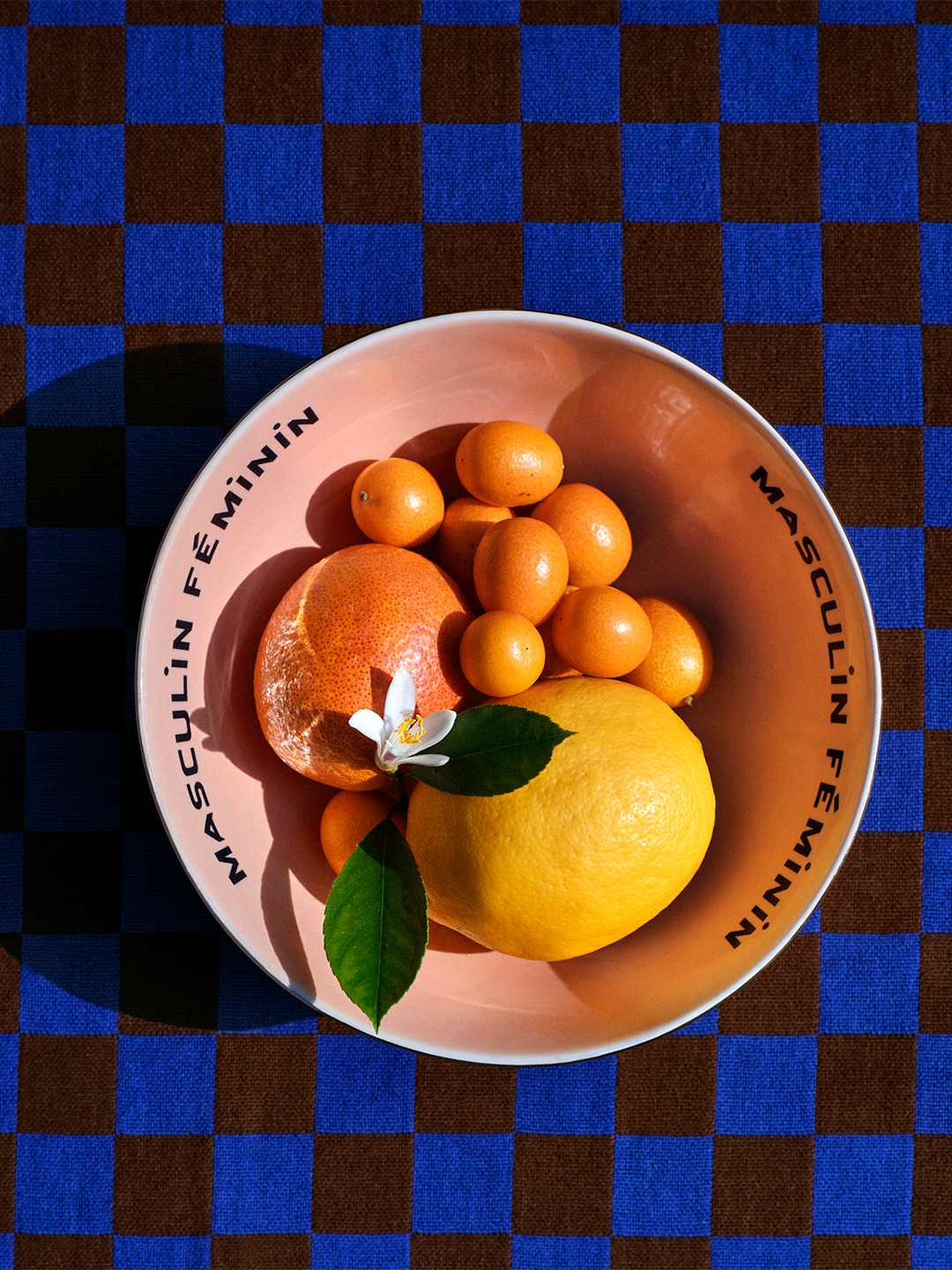 Pink bowl with fruit on checkerboard tablecloth