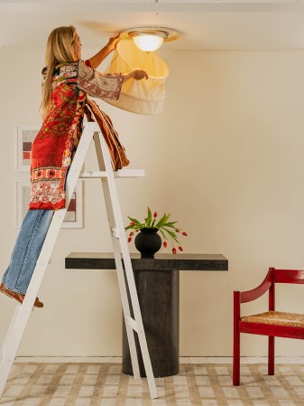 woman installing light shade