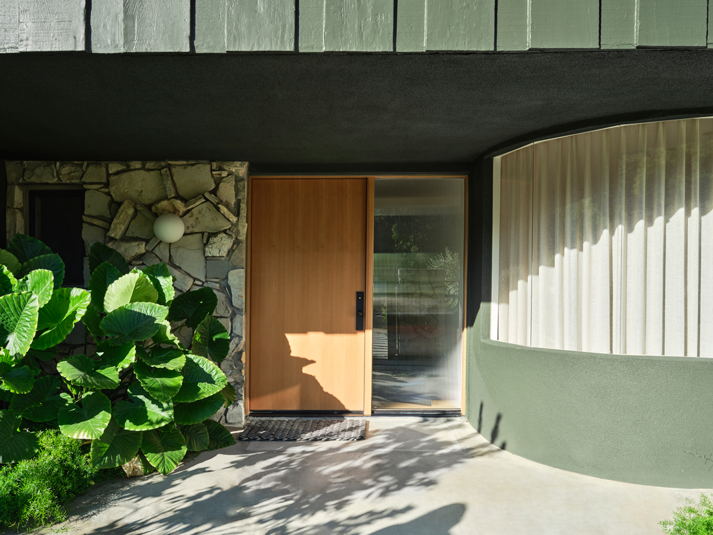 Front door with curved room and window next to it