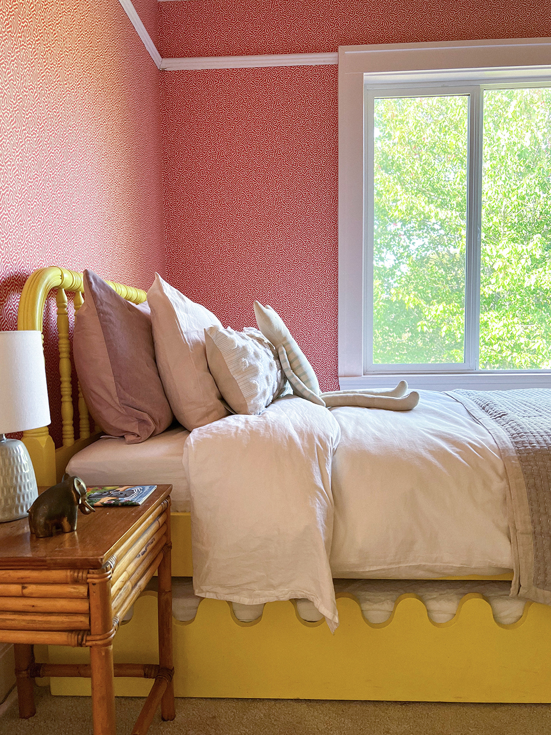 Yellow kid's bed with squiggly trundle below.