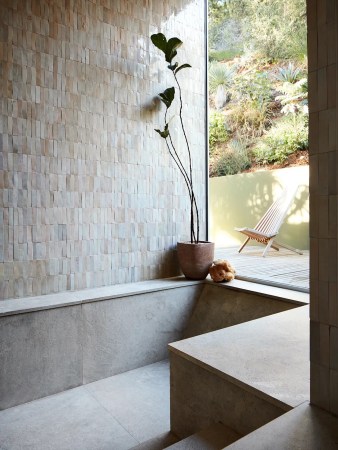 Bathroom with a big window and walk-in tub covered in white tile.