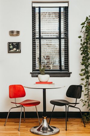 Circle table with two chairs next to a window