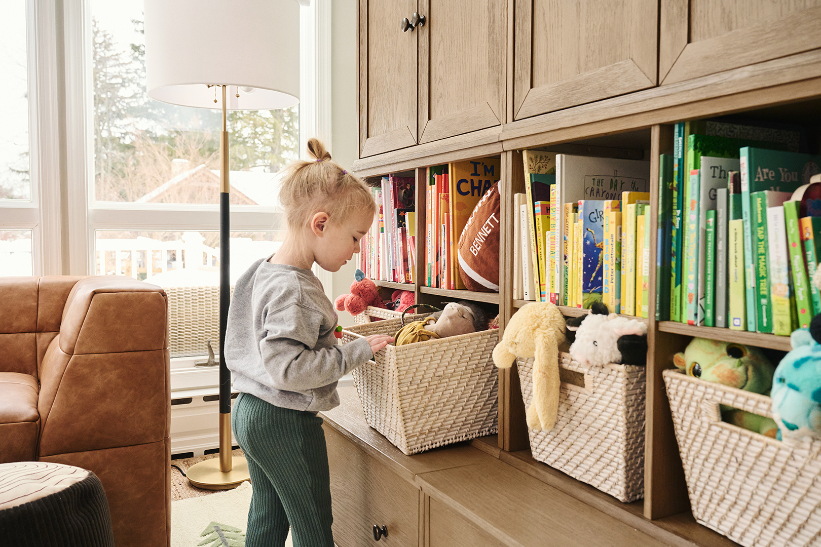 Young girl looking into a bin of stuffed animals