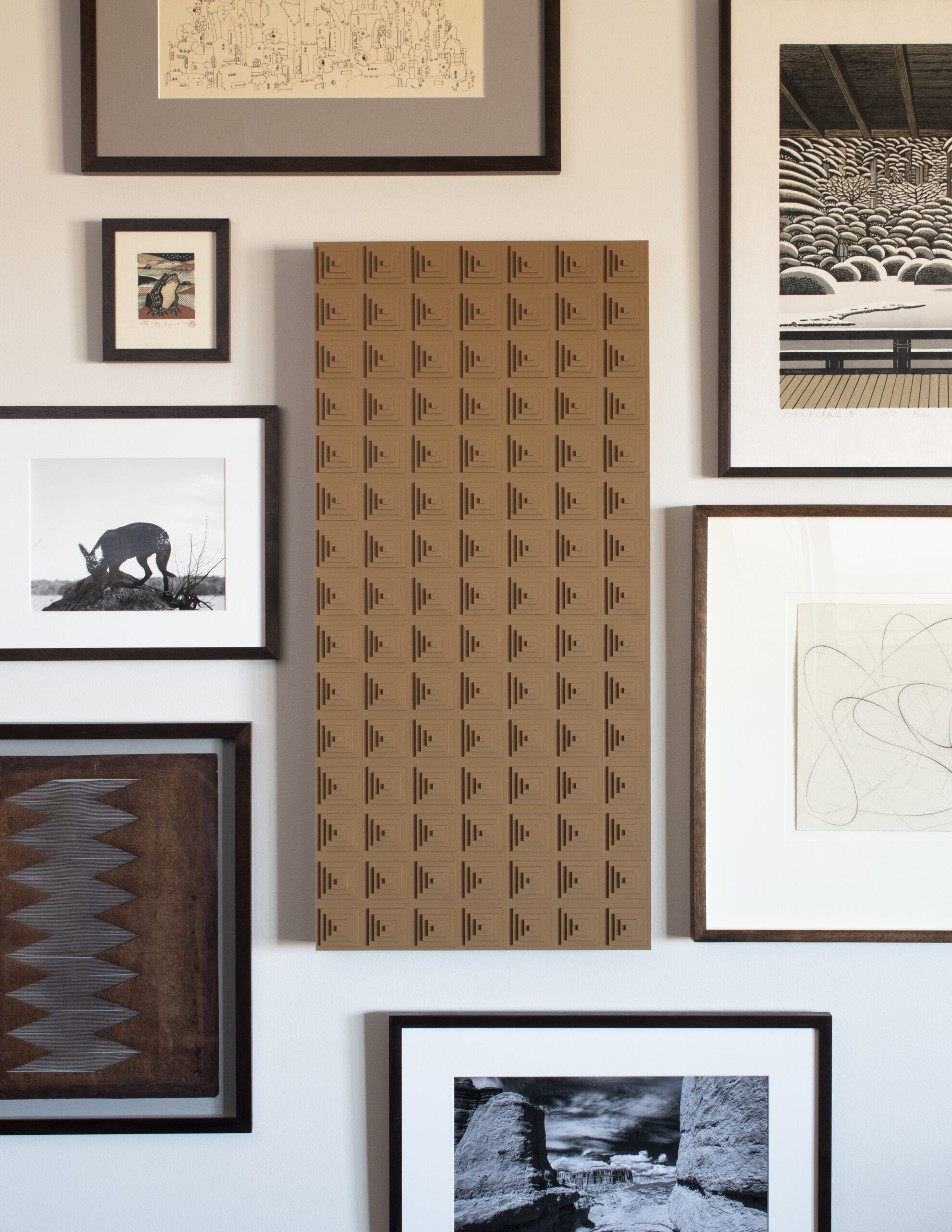 Gallery wall with leather art work featuring concentric squares.