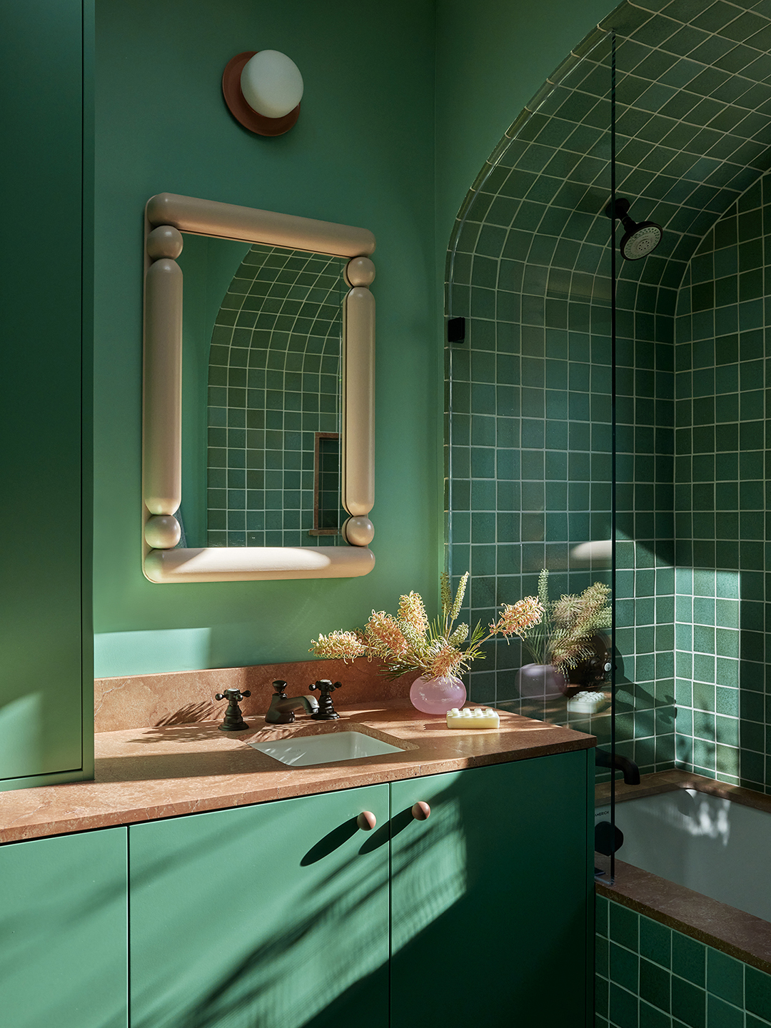 Green bathroom with green tile and cabinets