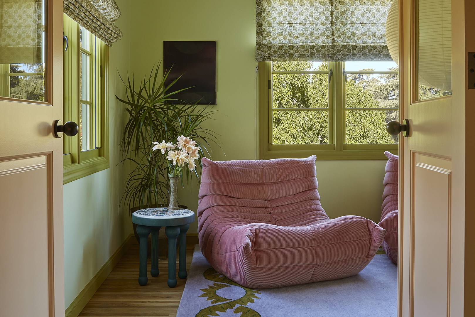 Green sunroom with pink togo chair