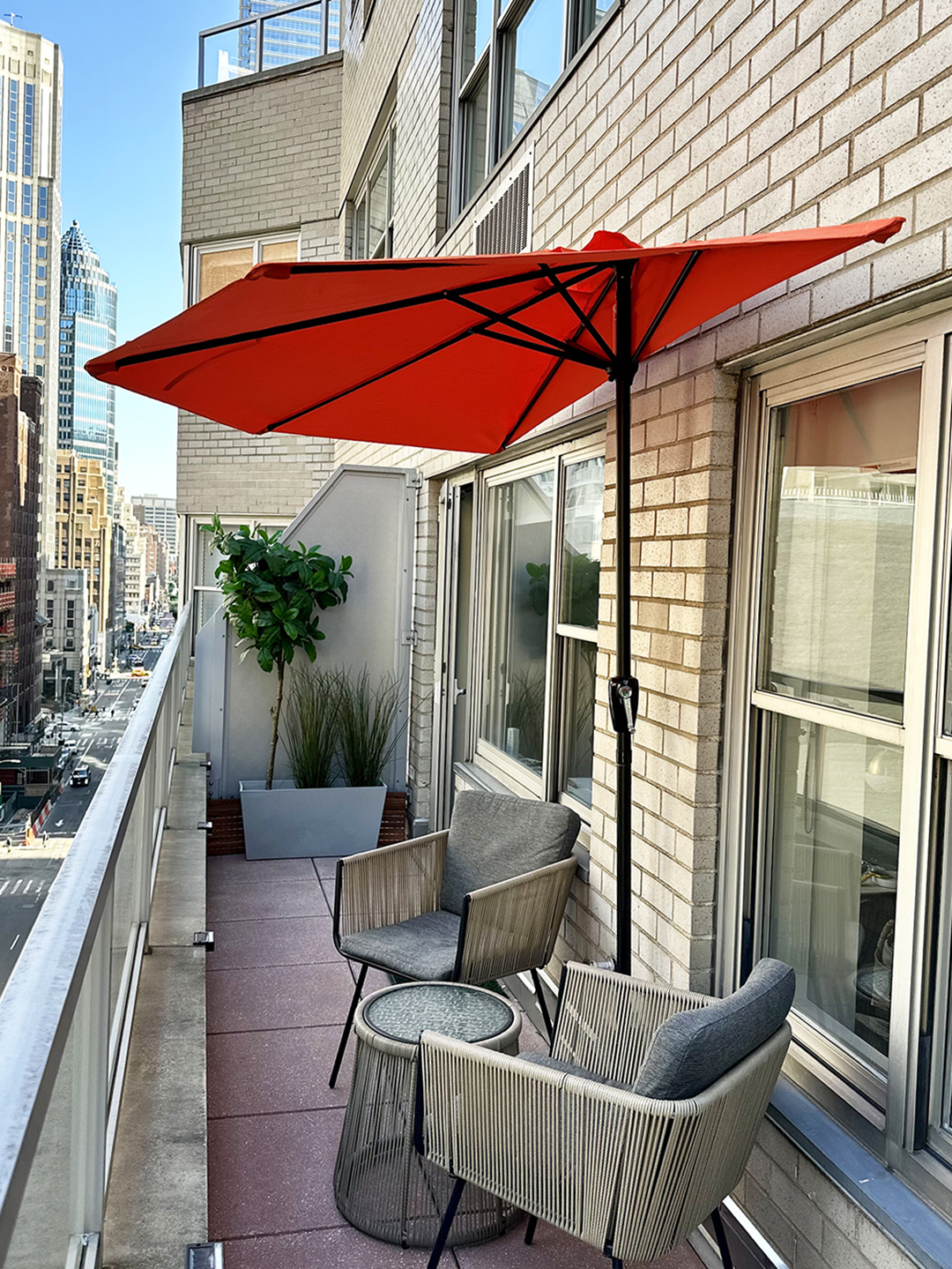 Open orange half-circle umbrella on narrow NYC terrace