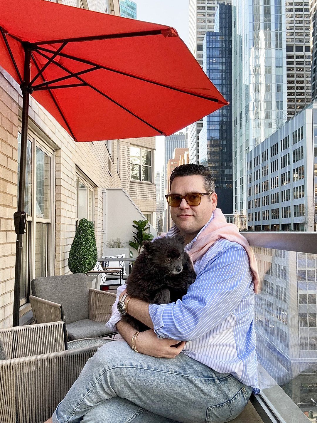 Man holding dog on narrow NYC terrace