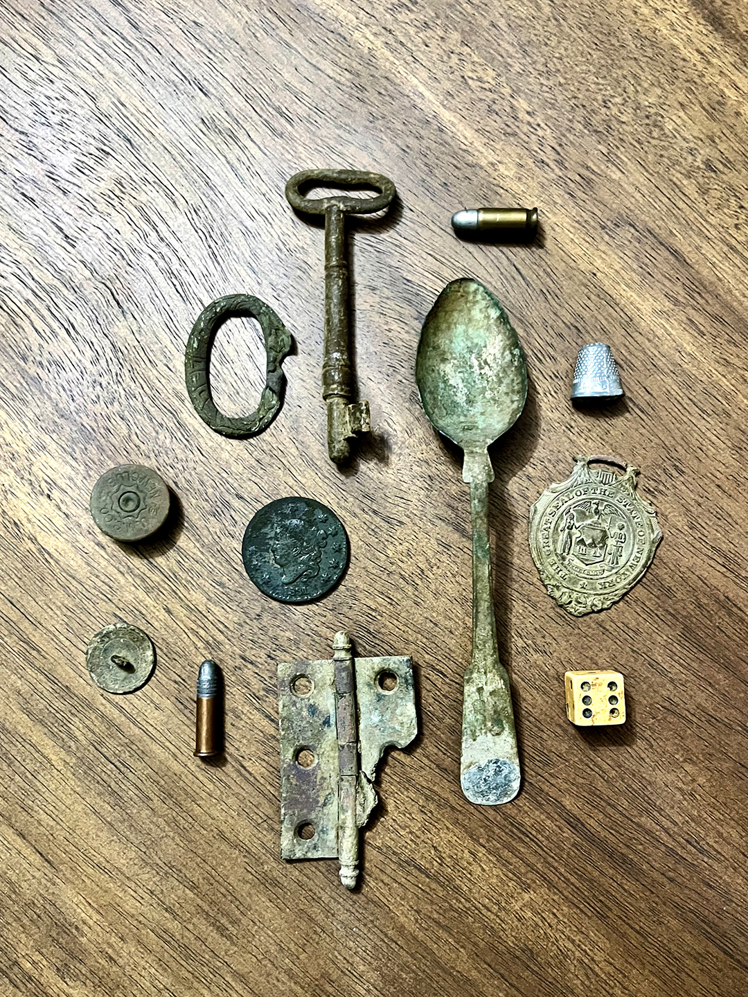 Found objects, like a spoon and coin, on a wooden table