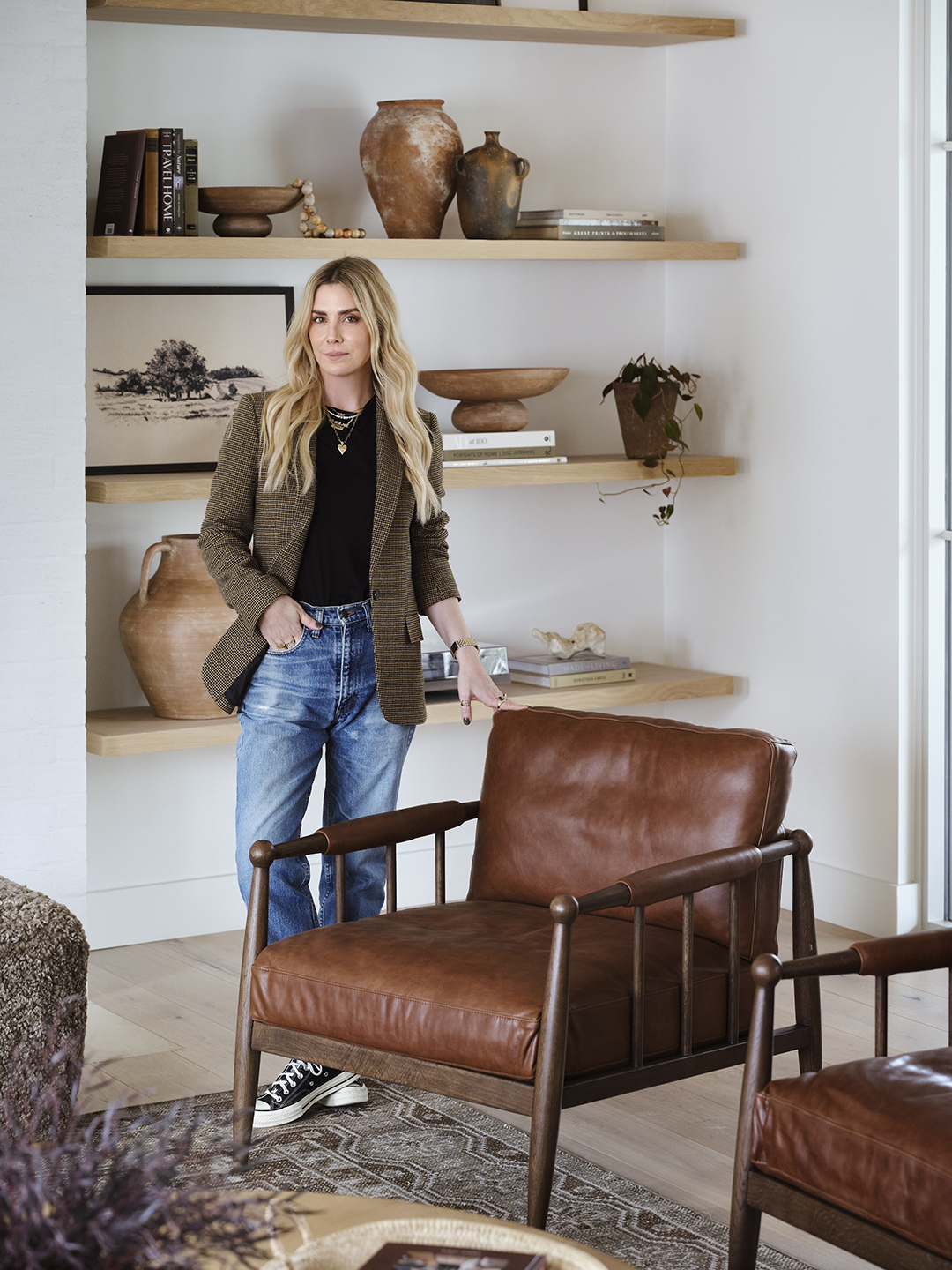 woman standing next to leather chair