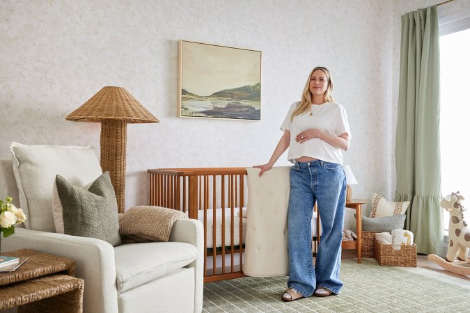 Pregnant woman posing in front of crib