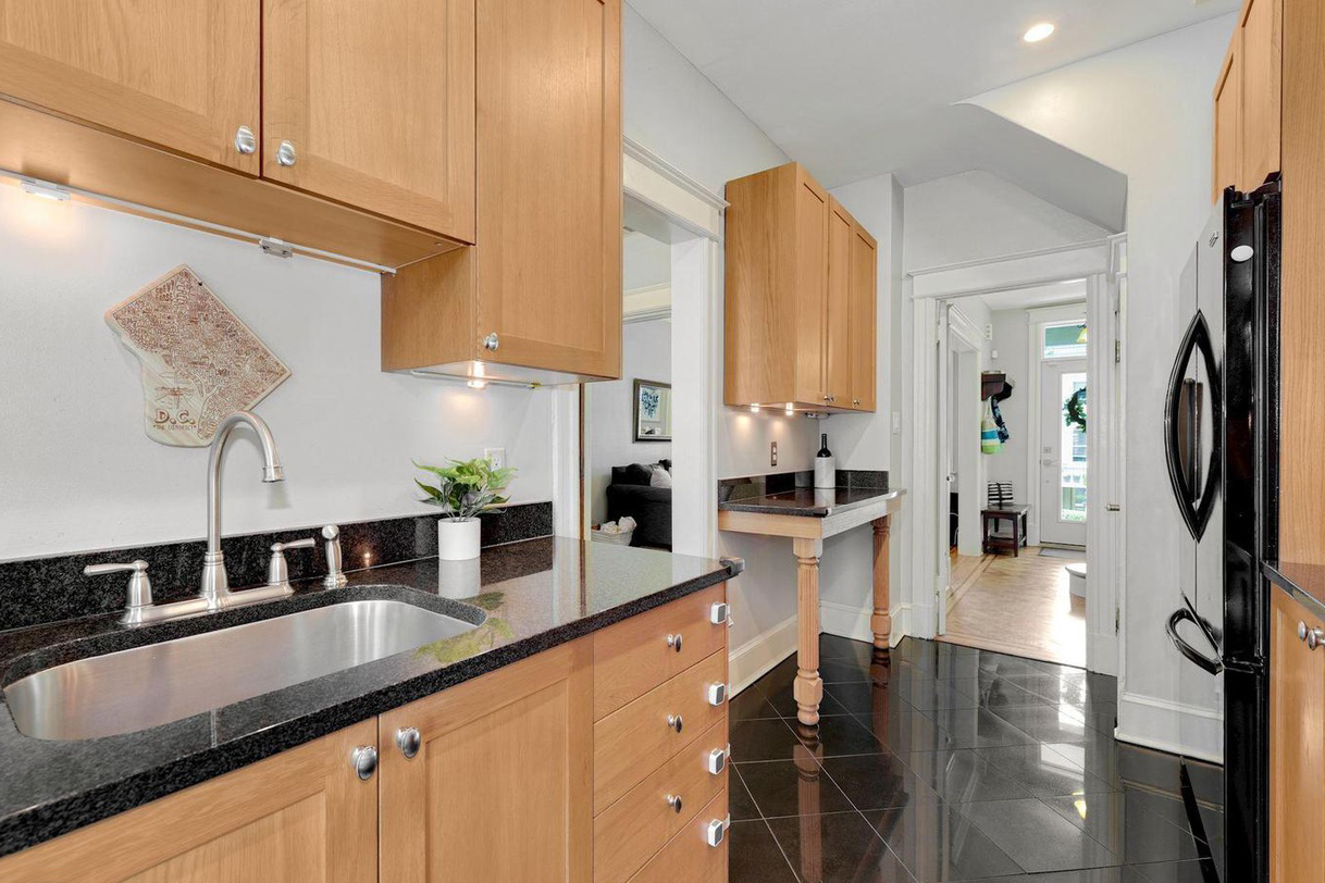 wood cabinets and black tile floor