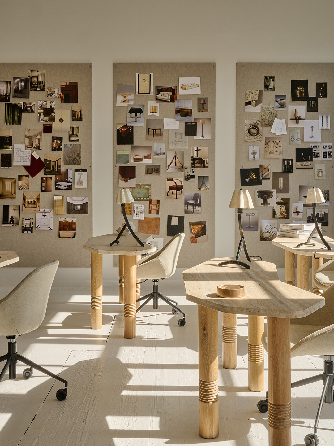 travertine desks next to wall moodboards