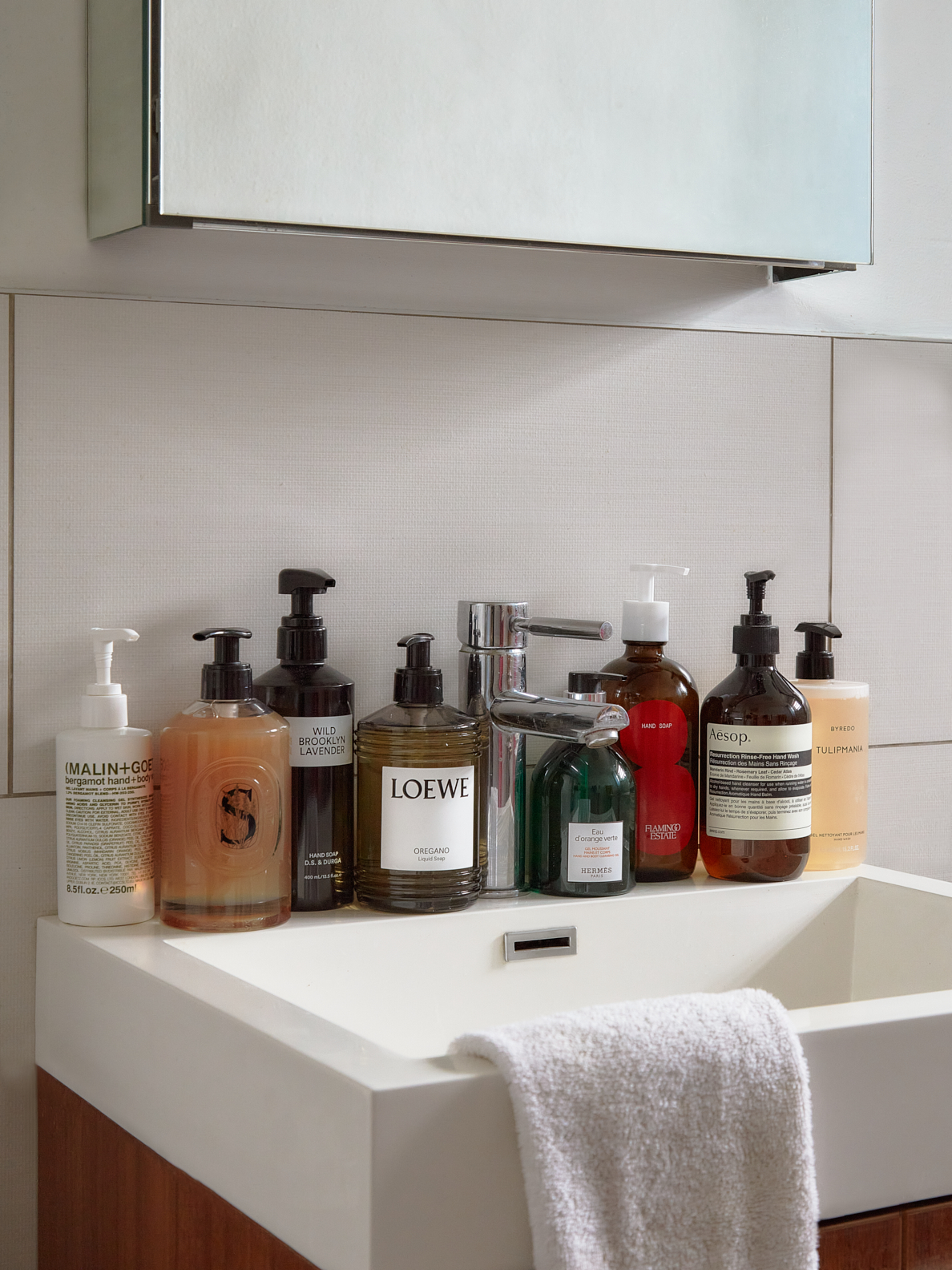 handsoaps along the counter of a bathroom sink