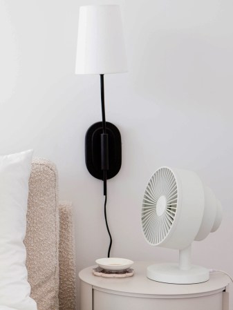 fan next to a bed
