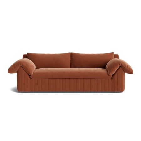  rust red sofa with pillows over arms