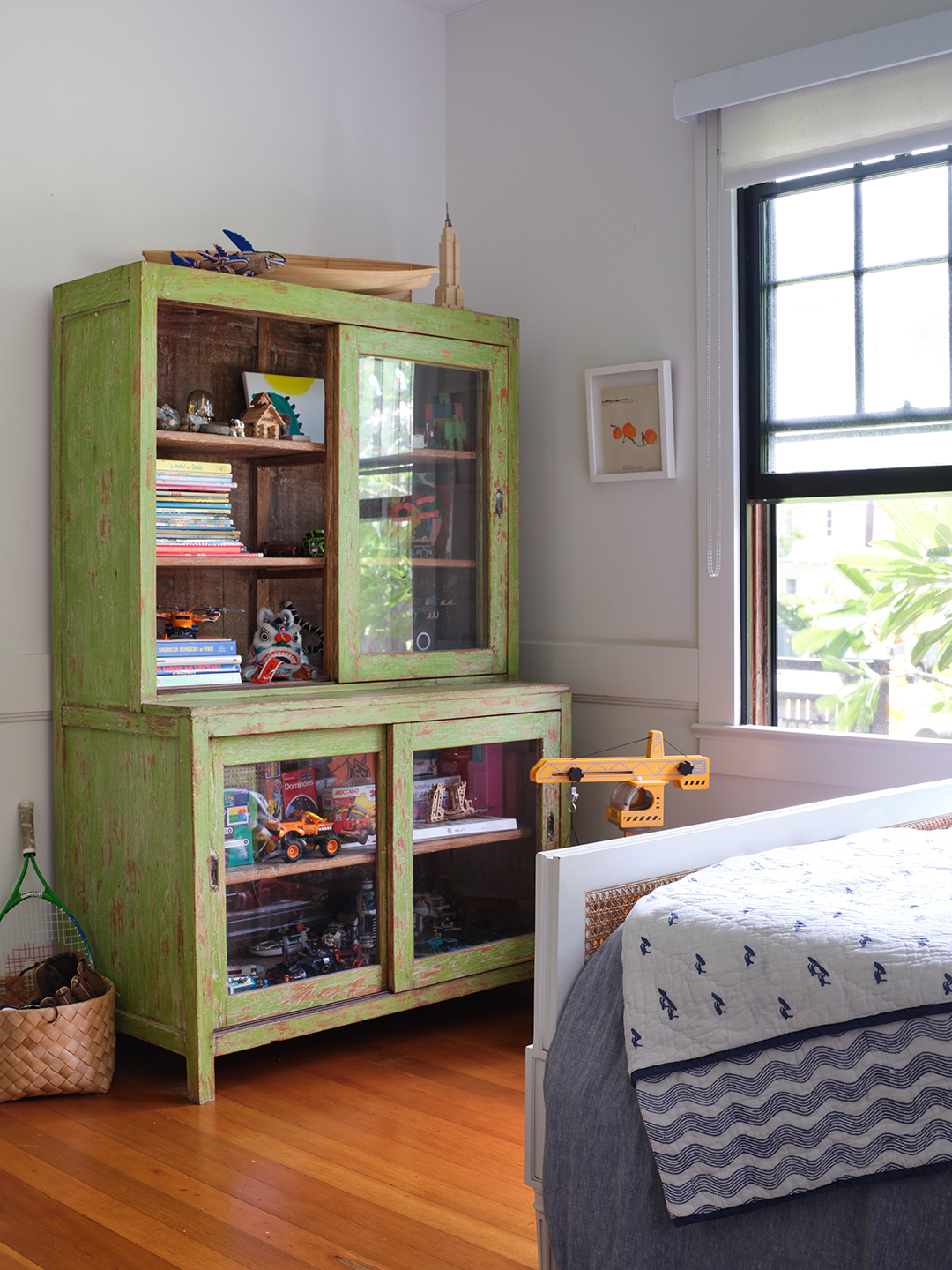 kids room with green cabinet holding toys