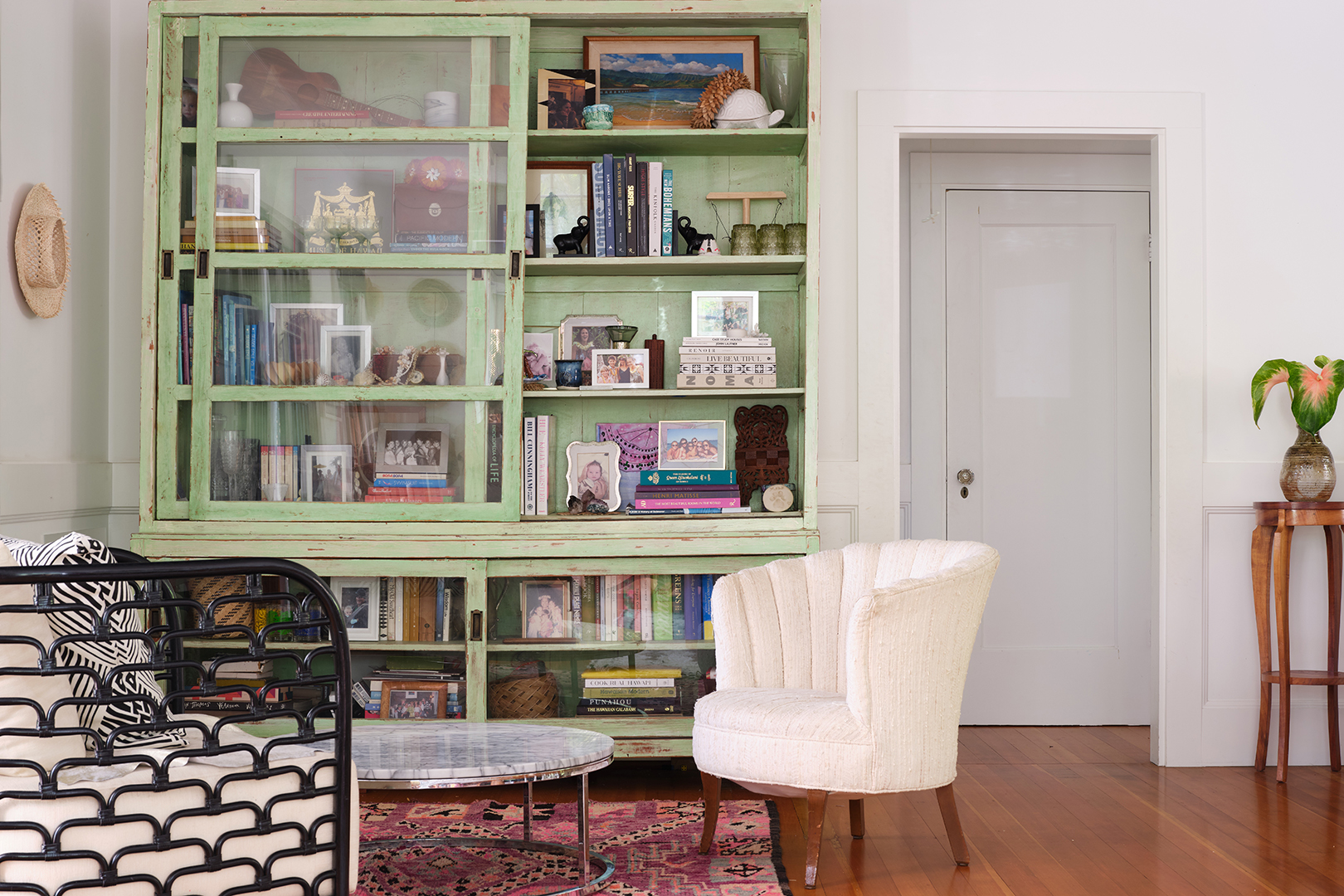 white side chair in front of green bookshelf