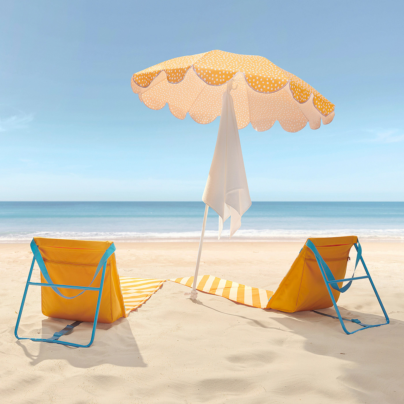 yellow umbrella and two yellow chairs on a beach