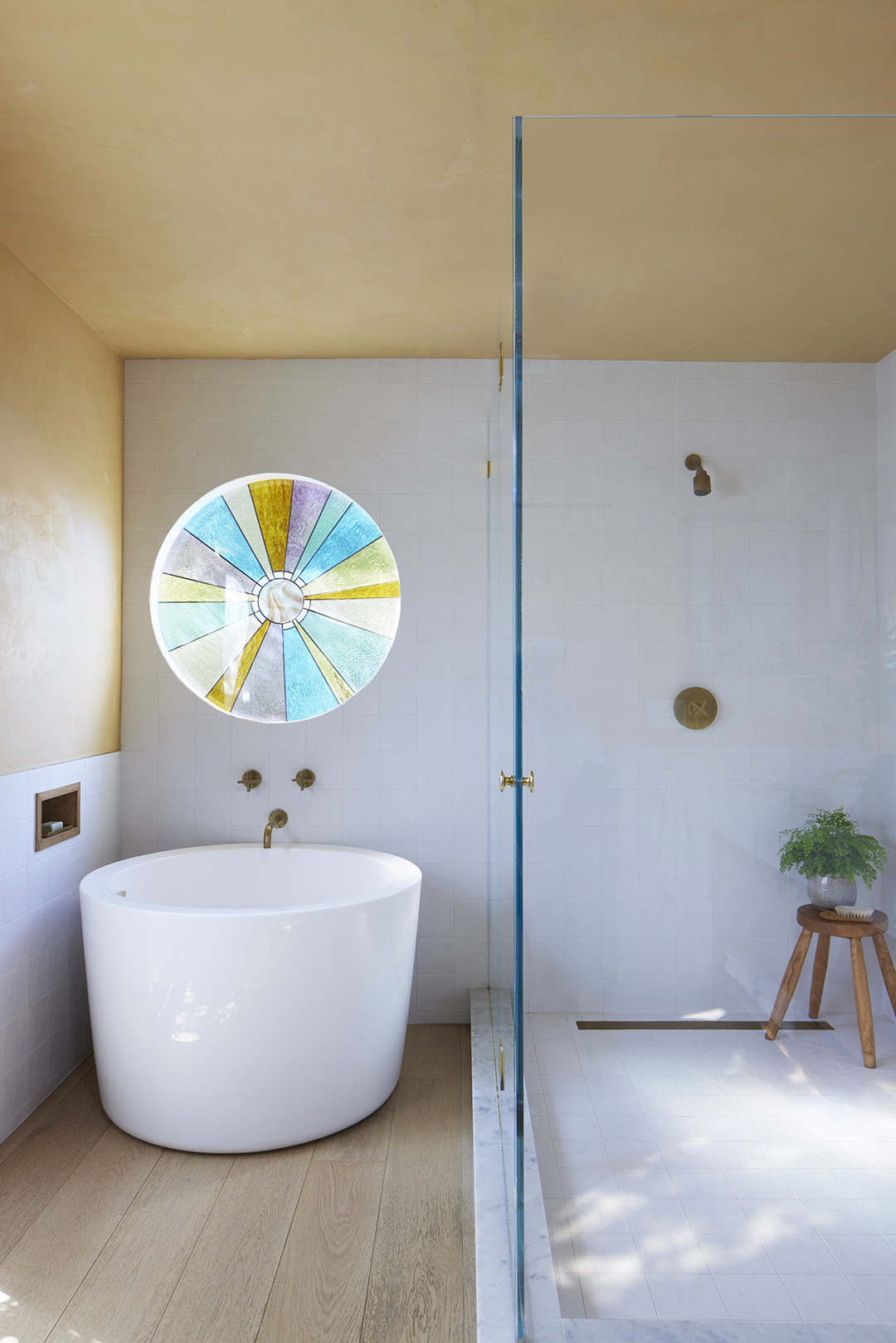 round stained glass window over tub