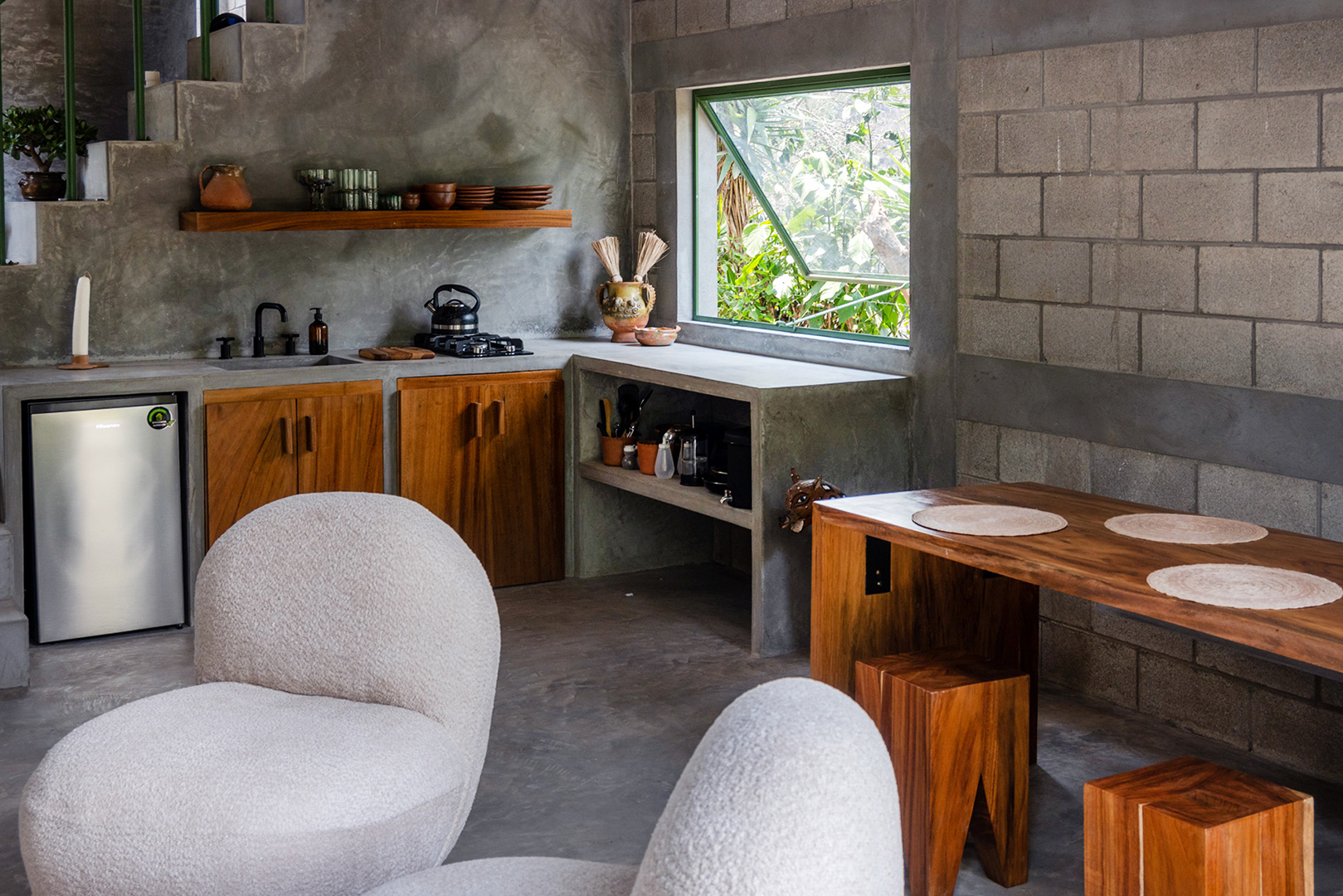 boucle seating near kitchen in concrete living room