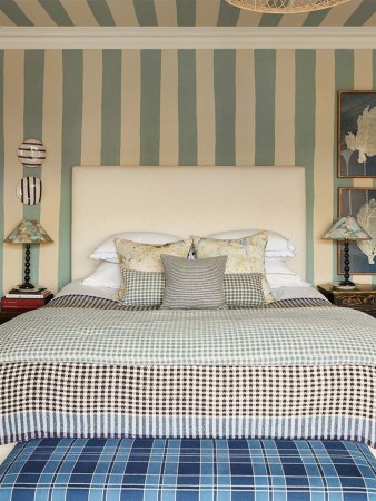 Bedroop with blue and white stripe painted walls and checked bedding