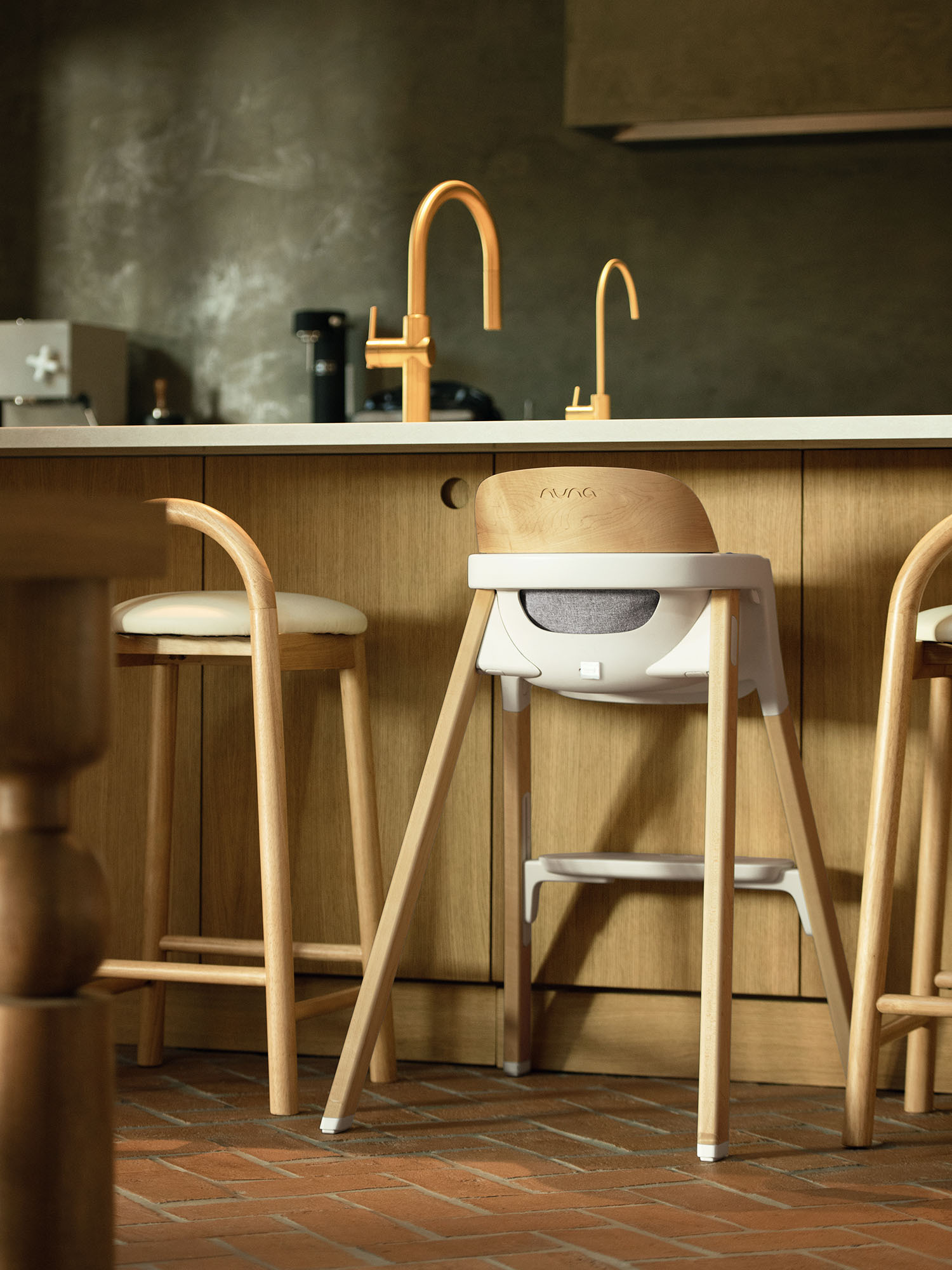 Nuna wood high chair against wood bar counter.