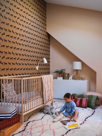 Toddler playing next to crib