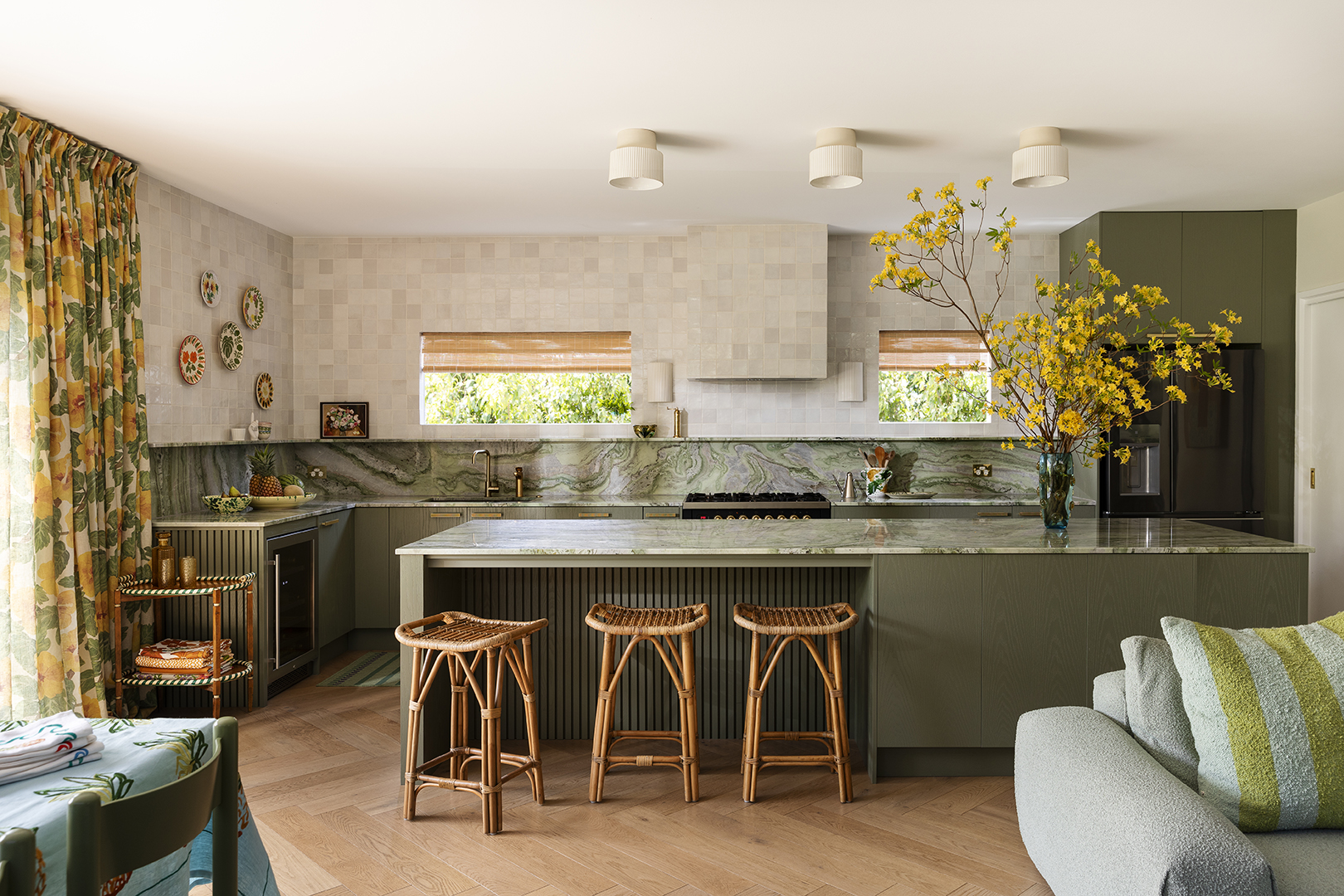 Open kitchen with green cabinetry. 