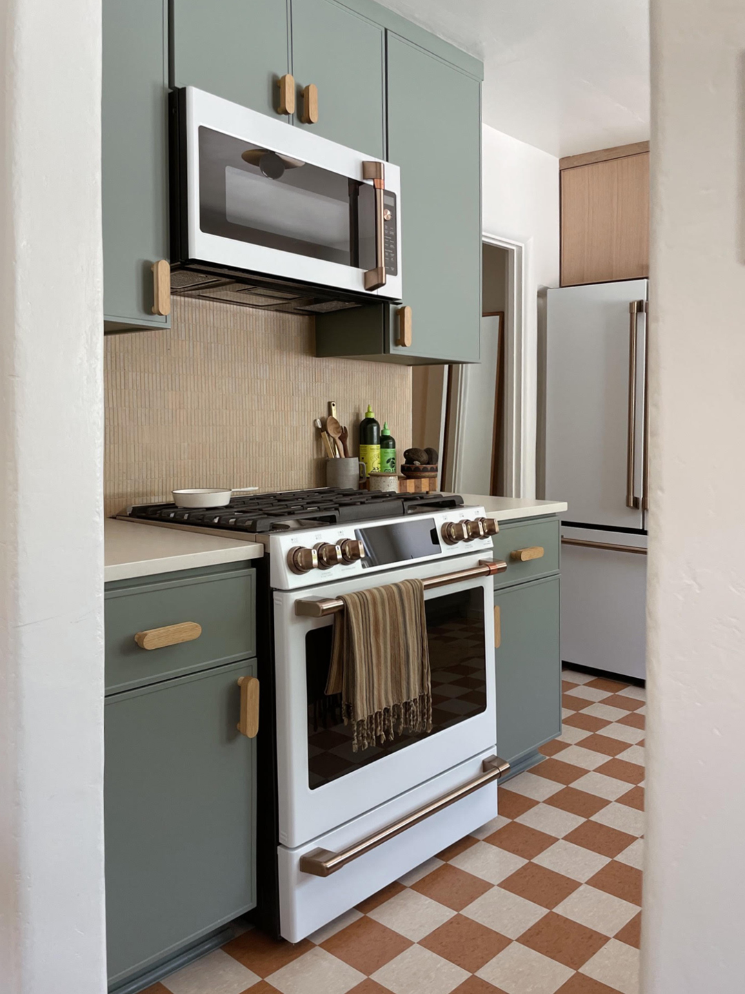 green cabinets around white cafe range