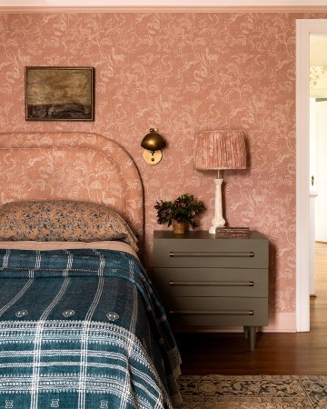 Bedroom with matching floral wallpaper, headboard, and lampshade