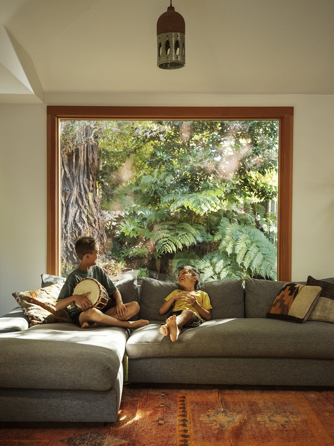 kids on sofa in front of large window