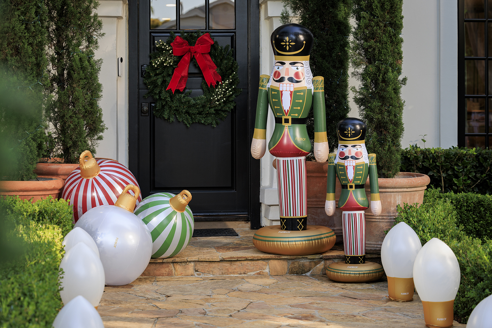 Inflatable nutcracker and ornament decorations at a front door