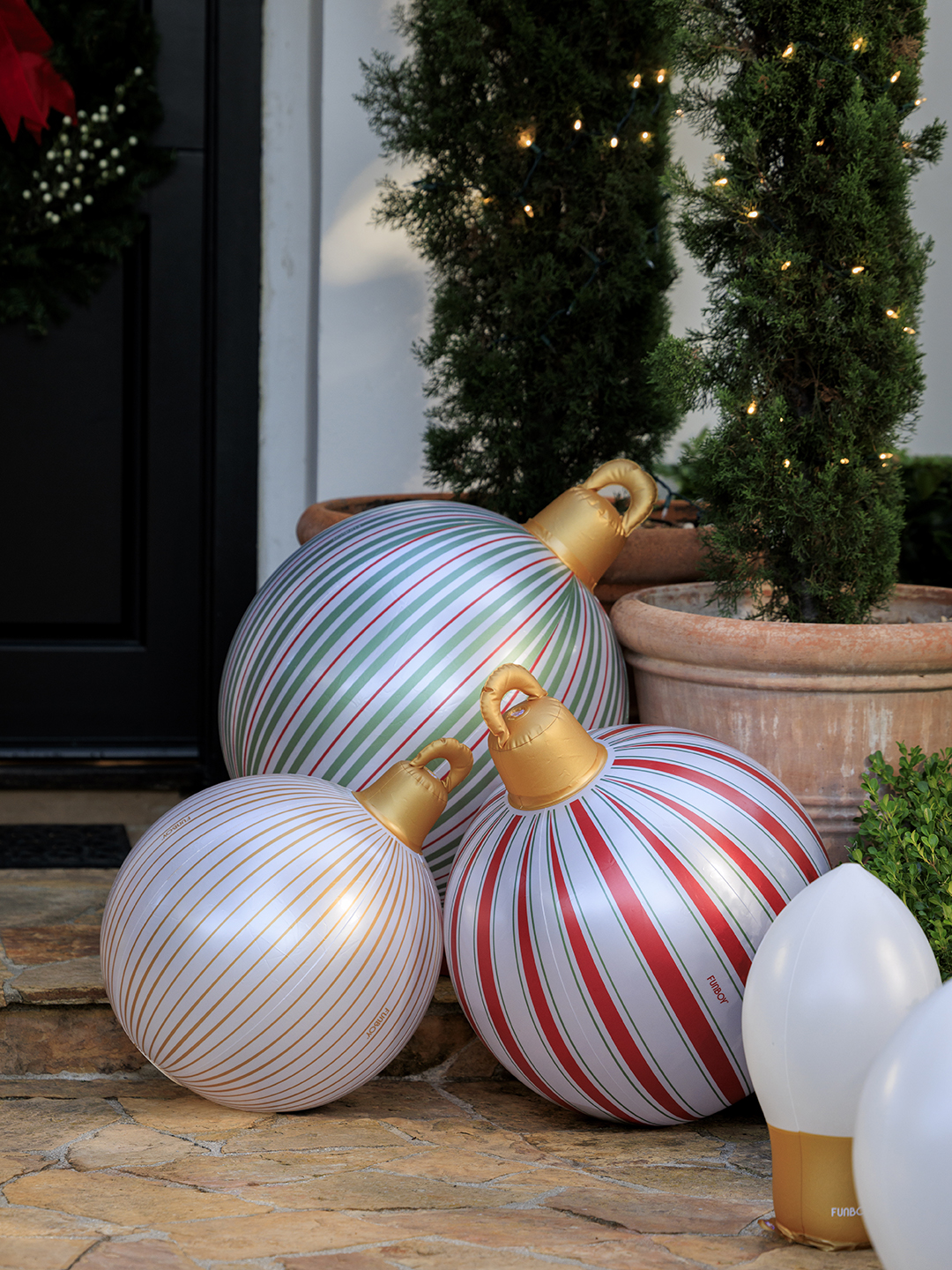 A trio of inflatable ornaments next to a front door