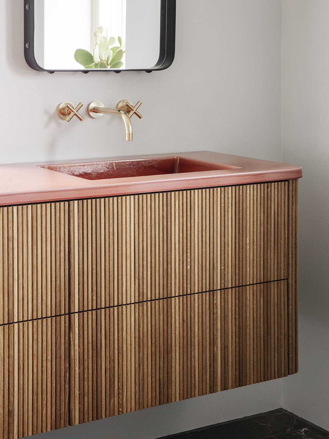 fluted wood vanity with pink counter