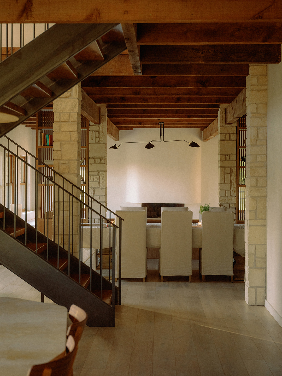 view of dining room beyond iron stairs