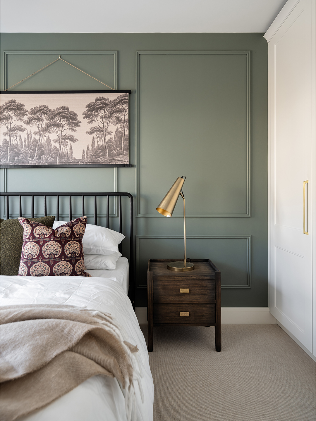 A bedroom with a large bedside lamp.