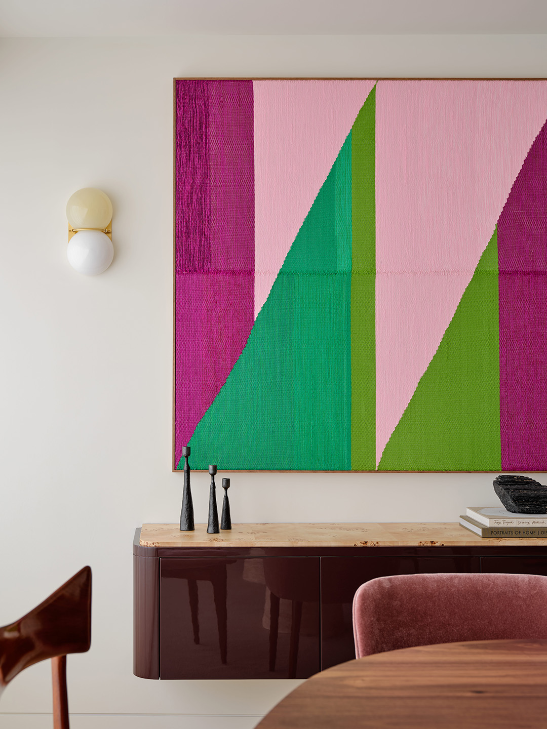 Dining area with textured artwork.