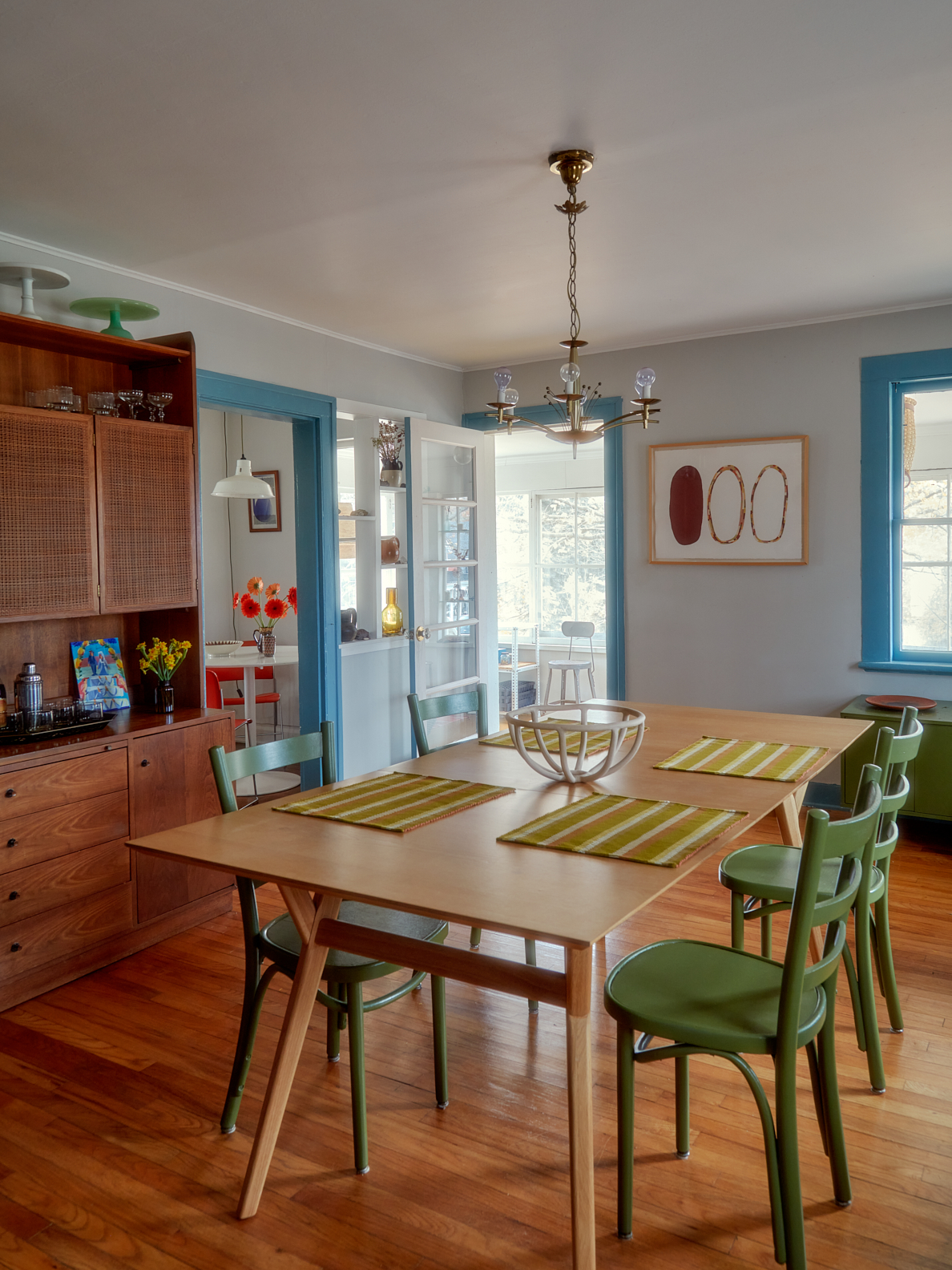 Dining room with green chairs and blue molding.