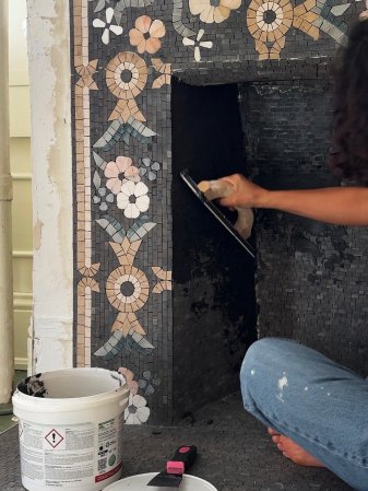 Fireplace being tiled with a mosaic