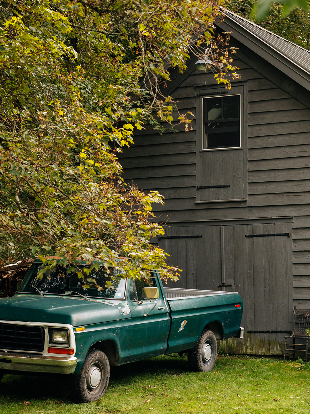 Black barn and mature trees