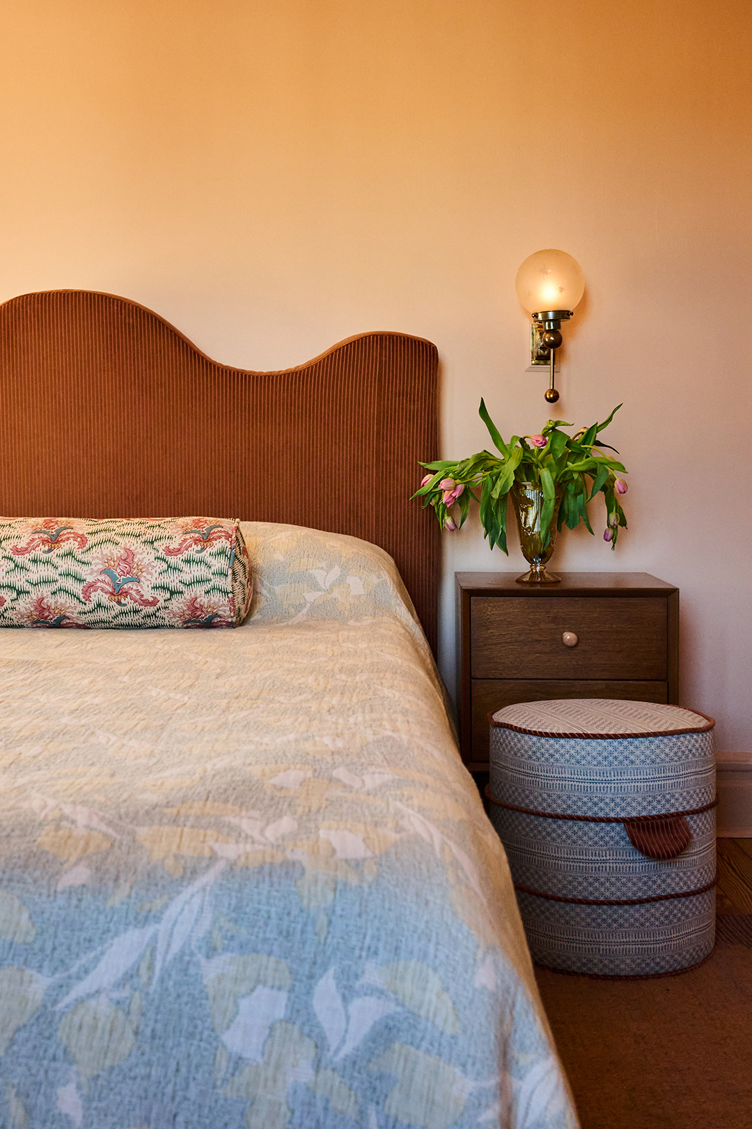 patterned ottoman in front of nightstand